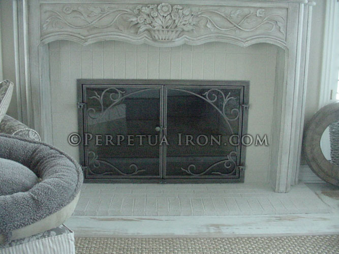 Mobile, lightweight custom made wrought iron fireplace screen or fire screen.