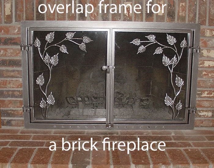 A bright pewter finished fireplace screen surface mounted to the fireplace surround features a vine and leaf motif.