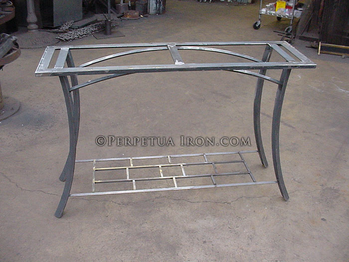 Welded and bent steel side table in process without stone top.