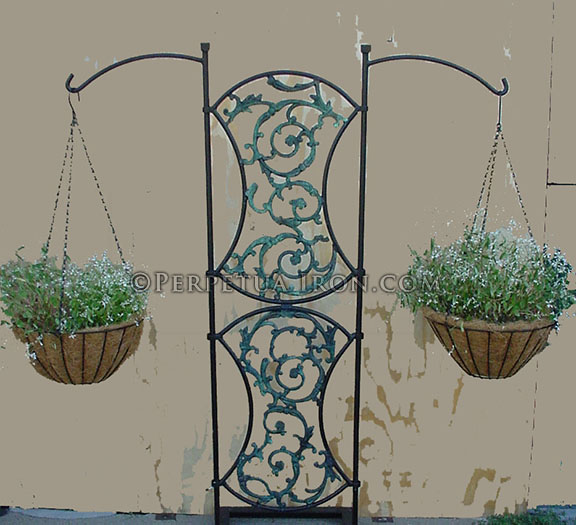Ornate iron plant stand with shield designs.
