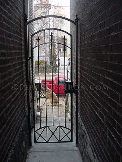 Decorative iron alley way gate, finials and X patterns, key pad lock.