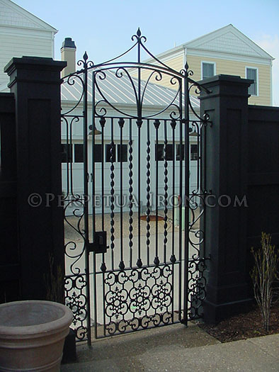 custom designed, very ornate, iron courtyard gate with panels, custom design with keypad entry.