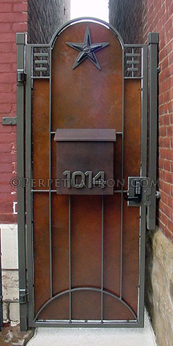 Interior view of a decorative gate featuring integrated mailbox, keypad latch and a rust on black patina.