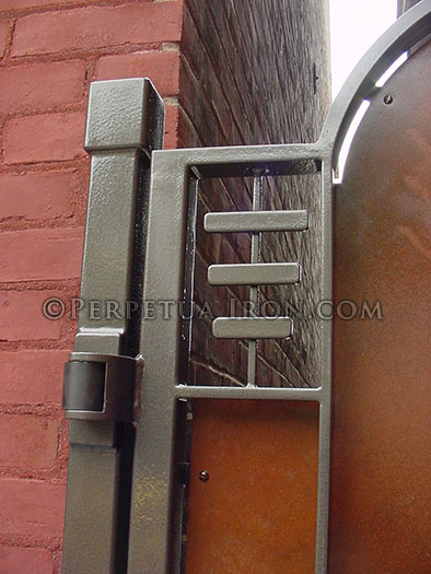 Heavy duty self closing hinges on a custom gate where the hinge is mounted to the front on a square post in front of an old bringk building instead of mounting it to the building.