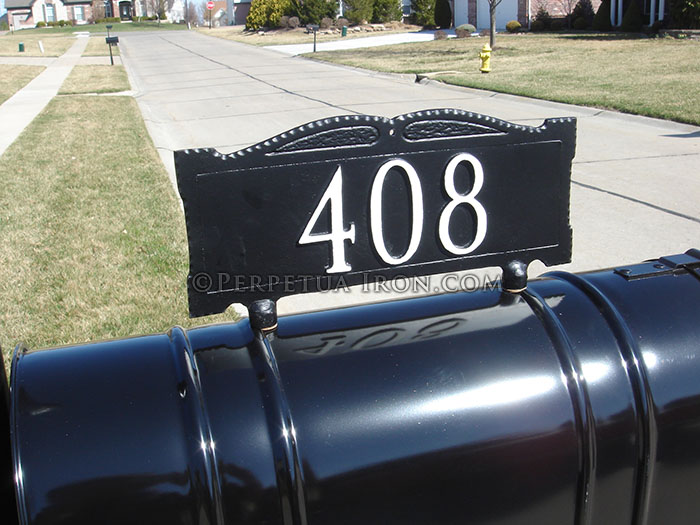 Address sign mounted on top of mailbox.