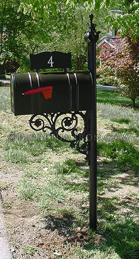 Mailbox in a grassy area with red flag down and the number 4 on a plate above the box.