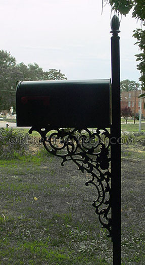 backlit mailbox with large cast iron bracket. The post with its decorative finial is taller than the box 