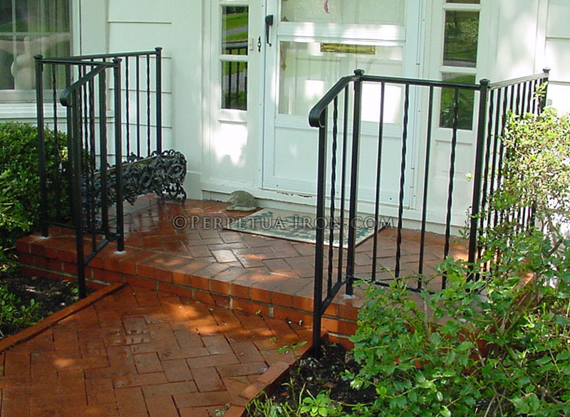 Wrought iron porch railing, design is alternating twisted pickets.