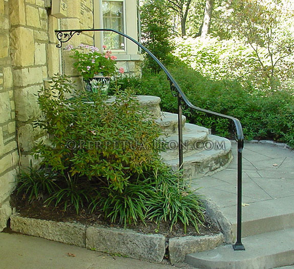Flowing wrought iron handrail only, curved on site, with cast iron scrolls.