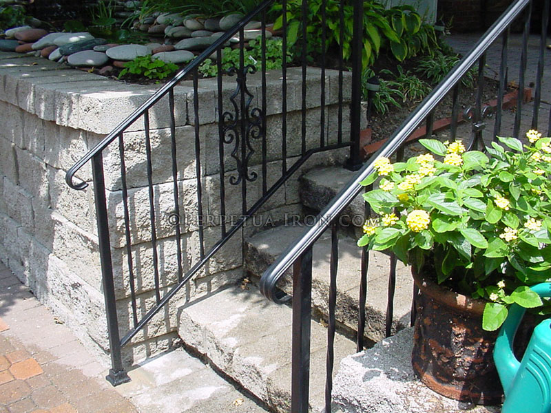 Wrought iron  railing for steps with twisted pickets and cast iron elements.