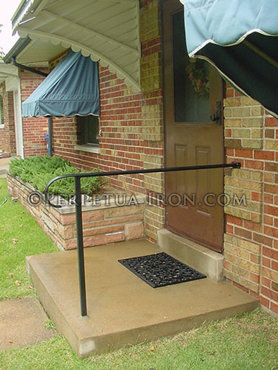 Wrought iron handrail and post for simple porch.