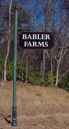 Large sign for a subdivision with green post, black sign with the word BABLER FARMS in white letters.