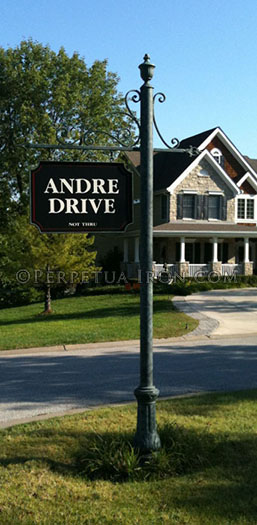 This iron street sign for a subdivision has hand made scrolls and a cast iron base. It reads Andre Drive.